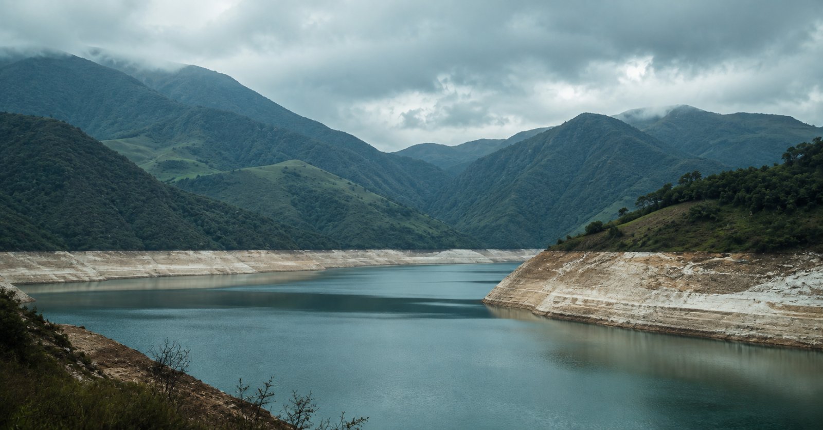 Embalse con nivel bajo mostrando la marca del agua en las paredes de tierra